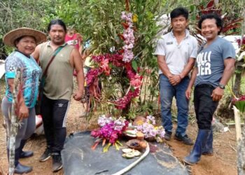 Habitantes Kichuas de Sarayaku, junto a la tumba del familiar, rezan, depositan alimentos y flores.