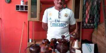 Ilber Mesías Huilca, expone los artículos decorativos que elabora con material reciclable.