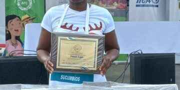 Teodolinda Quintero muestra ante el público la placa que la reconoce como la ganadora de la Feria Culinaria Saberes y Tradiciones.